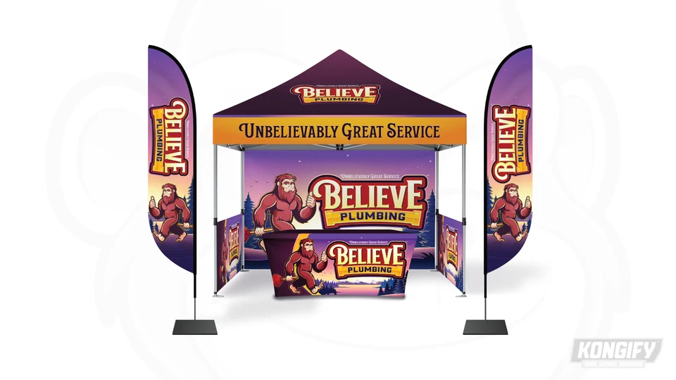 Believe Plumbing event display with a purple canopy, flags, mountain backdrop, branded table cover, and Bigfoot mascot.
